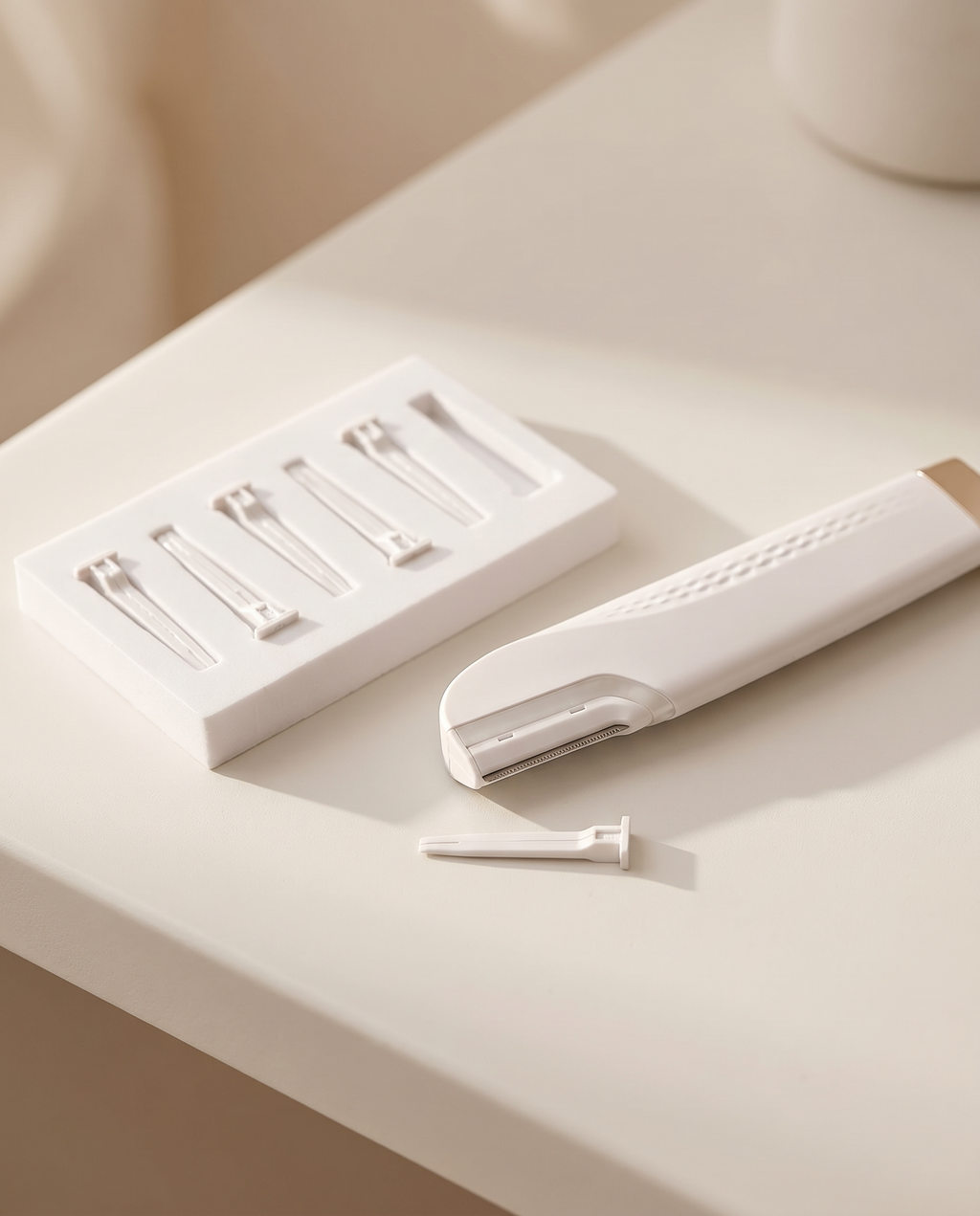 GlowPrep dermaplaning device with its set of replaceable blade heads